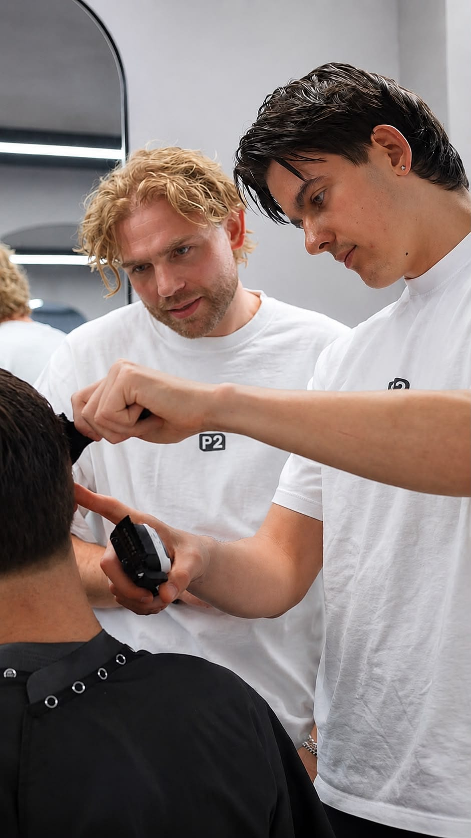 A senior stylist guiding a junior stylist during training at The P2 Collective